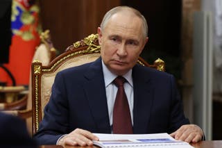 Russian president Vladimir Putin listens to Russian Academy of Sciences President Gennady Krasnikov during their meeting at the Kremlin in Moscow